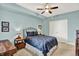 Comfortable bedroom with a ceiling fan, wood furniture, and serene blue walls at 622 E 10Th St # 310, Indianapolis, IN 46202