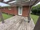 Relaxing back porch with wooden swing, brick wall, wooden pergola, and a view of the backyard at 6237 E Lynn Dr, Mooresville, IN 46158