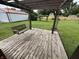 Spacious wooden back porch with a swing offering serene views of the expansive backyard and rustic wooden fencing at 6237 E Lynn Dr, Mooresville, IN 46158