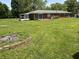 Expansive backyard with a brick fire pit, lush lawn, and mature trees at 6237 E Lynn Dr, Mooresville, IN 46158