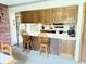 Eat-in kitchen features white countertops, wooden cabinetry, barstool seating and includes black microwave and oven at 6237 E Lynn Dr, Mooresville, IN 46158