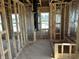 Unfinished bedroom with wall studs, plywood flooring, and several windows bringing in natural light at 637 Firefly Ct, Greenfield, IN 46140