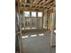 Spacious bedroom with wall studs, plywood flooring, and three bright windows at 637 Firefly Ct, Greenfield, IN 46140