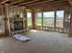Unfinished living room featuring a fireplace, wall studs, and several windows offering scenic views at 637 Firefly Ct, Greenfield, IN 46140