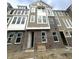 New construction of a brick and vinyl townhome exterior featuring white trim and many windows at 7313 Bayview Run, McCordsville, IN 46055