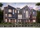 View of the new construction townhomes featuring brick and siding exteriors, colorful doors, and manicured lawns at 7339 Bayview Run, McCordsville, IN 46055