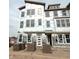 Three-story home featuring white trim windows and a white door with sidelights, in the process of being bricked at 7355 Bayview Run, McCordsville, IN 46055