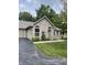 Charming home featuring a manicured lawn, arched windows, and a brick facade with beautiful landscaping at 7536 Briarstone Dr, Indianapolis, IN 46227