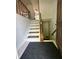 Entryway featuring tiled floor, coat closet, and carpeted stairs with wooden handrail at 7607 Ardwell Ct, Indianapolis, IN 46237