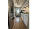 Functional kitchen layout featuring white cabinets, stainless steel appliances, and wood-look floors at 7607 Ardwell Ct, Indianapolis, IN 46237