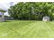 Lush green backyard featuring a storage shed and mature trees at 7741 Long Branch Dr, Indianapolis, IN 46259