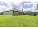 Well-manicured backyard with a brick house, lush green grass, and a wooden fence at 7741 Long Branch Dr, Indianapolis, IN 46259