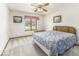Cozy bedroom with neutral carpet, a ceiling fan, a window, and a comfortably sized bed at 7741 Long Branch Dr, Indianapolis, IN 46259