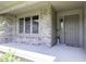 Inviting front entrance with a gray door, brick accents, and a sheltered concrete patio at 7741 Long Branch Dr, Indianapolis, IN 46259