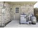 Exterior with a brick wall, a utility box, pipes, and a beige back door with nine glass panes at 7741 Long Branch Dr, Indianapolis, IN 46259