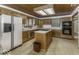 Well-appointed kitchen with wood cabinets, an island with a cooktop, and modern appliances at 7741 Long Branch Dr, Indianapolis, IN 46259