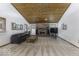 Spacious living room with a brick fireplace, carpeted floors, and a wood-paneled ceiling at 7741 Long Branch Dr, Indianapolis, IN 46259