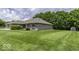 Expansive lawn surrounding a well-maintained single-story brick home with lush greenery at 7741 Long Branch Dr, Indianapolis, IN 46259