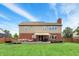 Expansive backyard featuring a well-maintained lawn, brick house, and a cozy deck perfect for outdoor relaxation at 8030 Parcrest Ct, Indianapolis, IN 46259