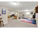 Finished basement area with comfortable seating, fitness equipment, and neutral walls, offering versatile space for relaxation at 8030 Parcrest Ct, Indianapolis, IN 46259