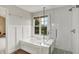 Well-lit bathroom showcasing a modern soaking tub, a clear glass shower, and white wainscoting at 8030 Parcrest Ct, Indianapolis, IN 46259
