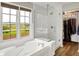 Spa-like bathroom featuring a soaking tub, glass-enclosed shower, and a walk-in closet at 8030 Parcrest Ct, Indianapolis, IN 46259