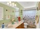 Colorful bathroom featuring a double vanity, patterned shower curtain, and bright green walls at 8030 Parcrest Ct, Indianapolis, IN 46259