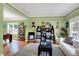 Open-concept living room showcasing hardwood floors, art and black shelving units at 8030 Parcrest Ct, Indianapolis, IN 46259