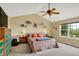 Relaxing main bedroom featuring a vaulted ceiling, ceiling fan, and large window with backyard view at 8030 Parcrest Ct, Indianapolis, IN 46259