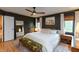 Comfortable main bedroom with paneled accent wall, bench, and ceiling fan at 8140 Springwater W Dr, Indianapolis, IN 46256
