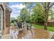 View of the back deck with wooden flooring furnished with modern gray Adirondack chairs and bistro table at 8663 N Commonview Dr, McCordsville, IN 46055