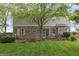 Lush green backyard featuring brick house, back deck and large shady trees on a cloudy day at 8663 N Commonview Dr, McCordsville, IN 46055