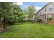 Spacious backyard with a well-maintained lawn, mature trees, and privacy fence at 8663 N Commonview Dr, McCordsville, IN 46055