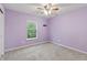 A bright bedroom featuring a ceiling fan, window, and neutral carpet with lilac painted walls at 8663 N Commonview Dr, McCordsville, IN 46055
