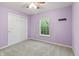 Bright bedroom with a ceiling fan, closet, window, and neutral carpet with lilac painted walls at 8663 N Commonview Dr, McCordsville, IN 46055
