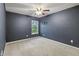 This bedroom has cozy carpet, a ceiling fan, a window with a view, and painted navy blue walls at 8663 N Commonview Dr, McCordsville, IN 46055