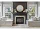 Close-up of a stylish fireplace with built-in benches and natural light from surrounding windows at 8663 N Commonview Dr, McCordsville, IN 46055