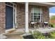 Inviting front porch with rocking chairs and lush landscaping provides a welcoming entrance to the home at 8663 N Commonview Dr, McCordsville, IN 46055