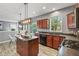 Well-lit kitchen features wood cabinets, stone countertops, stainless appliances, and an island overlooking the backyard at 8663 N Commonview Dr, McCordsville, IN 46055