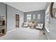 Bright living room with neutral tones, two chairs, and an area rug provides a relaxing space with ample natural light at 8663 N Commonview Dr, McCordsville, IN 46055