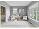 Bright living room with neutral tones, two chairs, and an area rug provides a relaxing space with ample natural light at 8663 N Commonview Dr, McCordsville, IN 46055