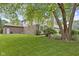 Spacious backyard with lush green grass, mature trees, and a brick and siding home at 9175 Lakewind Dr, Indianapolis, IN 46256