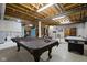 Unfinished basement with exposed beams, pool table, dart board and workout equipment at 9175 Lakewind Dr, Indianapolis, IN 46256