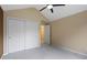 Neutral bedroom with beige walls, closet, fan, and an open door to the hallway at 9175 Lakewind Dr, Indianapolis, IN 46256
