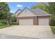 Charming home with a two-car garage, brick facade, and mature trees under a sunny sky at 9175 Lakewind Dr, Indianapolis, IN 46256