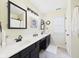 Bright bathroom featuring dual sinks, black cabinetry, and a large framed mirror at 9635 Shasta Dr, Fishers, IN 46038