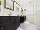 Well-lit bathroom with dual sinks set in white countertop and black cabinets at 9635 Shasta Dr, Fishers, IN 46038