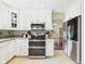 Bright kitchen featuring stainless steel appliances, white cabinetry, and tile flooring, offering a modern cooking space at 9635 Shasta Dr, Fishers, IN 46038