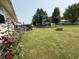 Spacious backyard with a cozy fire pit, wooden deck, beautiful roses, and lush green grass at 106 9Th St, New Market, IN 47965