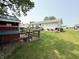 Spacious backyard featuring a chicken coop, deck, patio with grill, and lush green grass at 106 9Th St, New Market, IN 47965